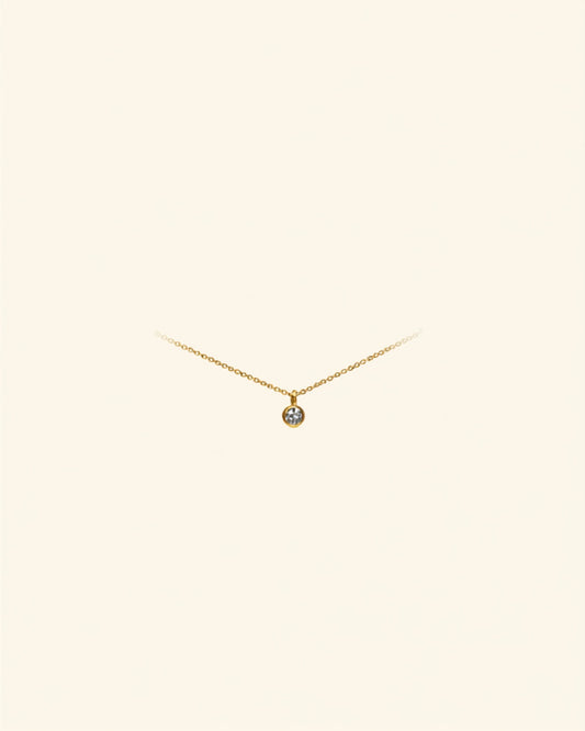 Initial letter gold anklet on cream background — Bare Gold waterproof jewelry
