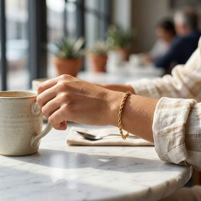 Twist chain bracelet worn on wrist, morning café scene — Bare Gold (photo B)